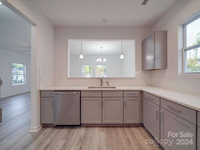 kitchen with dishwasher, gray cabinets, light wood-style flooring, and a sink