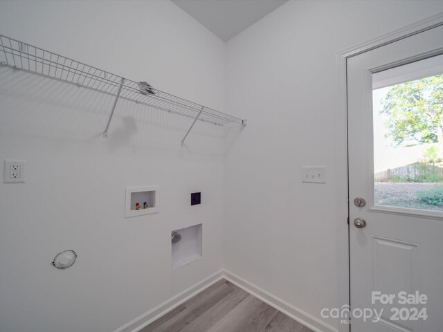washroom featuring baseboards, washer hookup, wood finished floors, electric dryer hookup, and laundry area