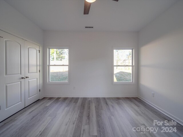 unfurnished bedroom with visible vents, a ceiling fan, a closet, baseboards, and light wood-style flooring