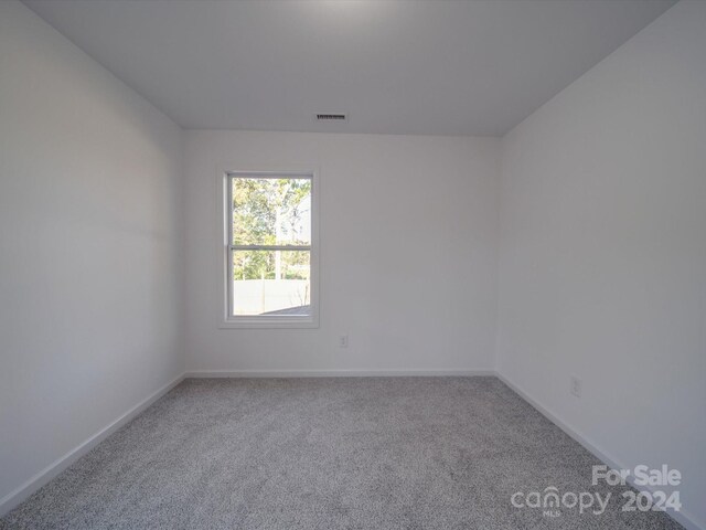 carpeted spare room with baseboards and visible vents