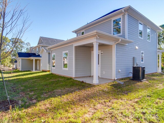 rear view of house with a patio area, a yard, and central air condition unit