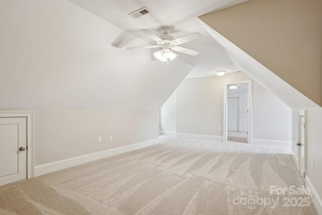 additional living space with carpet flooring, baseboards, visible vents, lofted ceiling, and ceiling fan