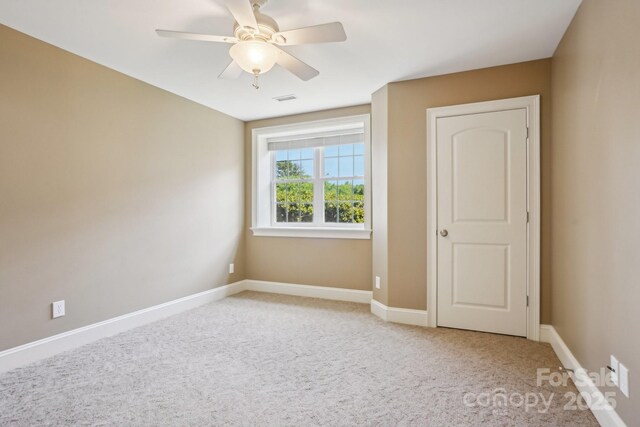 unfurnished bedroom with ceiling fan, baseboards, visible vents, and light carpet