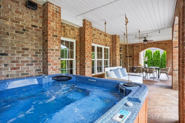 view of patio / terrace with an indoor hot tub, a ceiling fan, and outdoor dining area