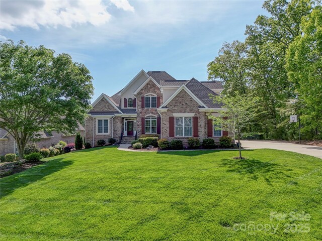 view of front of property with a front lawn and brick siding