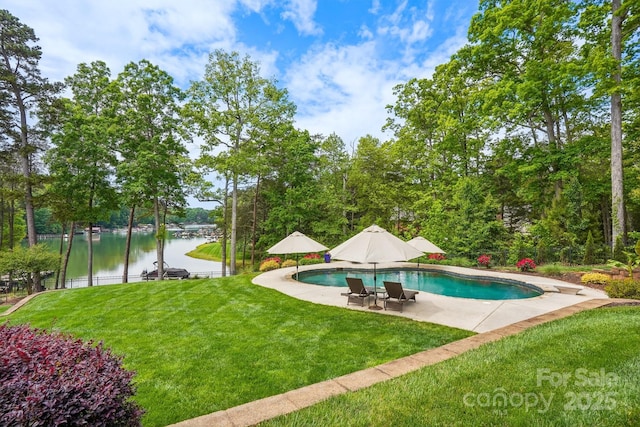 pool with a yard, a patio area, and a water view