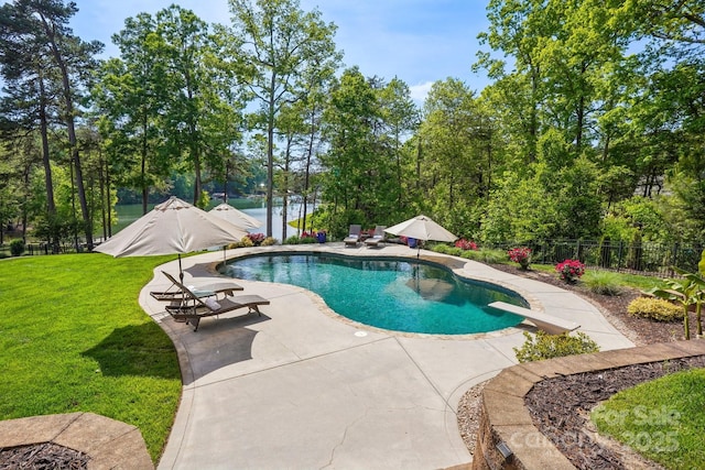 view of pool featuring a patio area, a lawn, fence, a diving board, and a fenced in pool