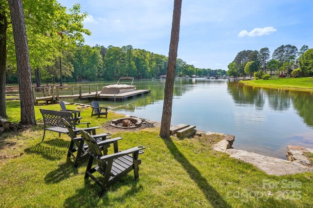 dock area featuring a fire pit, a yard, and a water view
