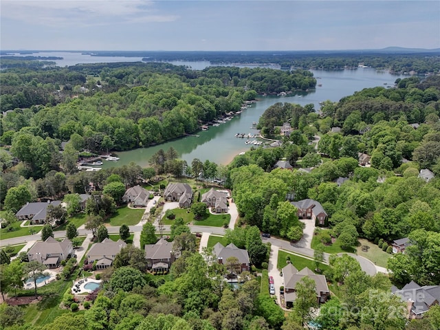 birds eye view of property with a wooded view, a residential view, and a water view