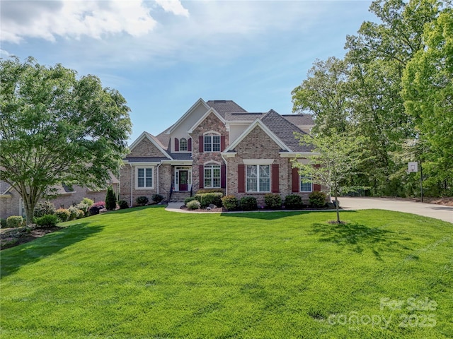 view of front of home with brick siding and a front yard