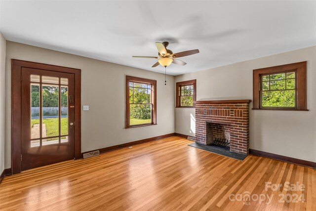 2523 Kool Park Rd NE, Hickory, NC 28601 - unfurnished living room featuring light wood finished floors, baseboards, a ceiling fan, and a brick fireplace
