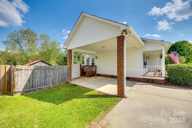 view of home's exterior with a yard and covered porch