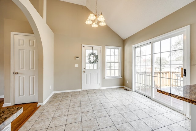 tiled foyer featuring high vaulted ceiling and a notable chandelier