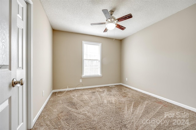 carpeted empty room with ceiling fan and a textured ceiling