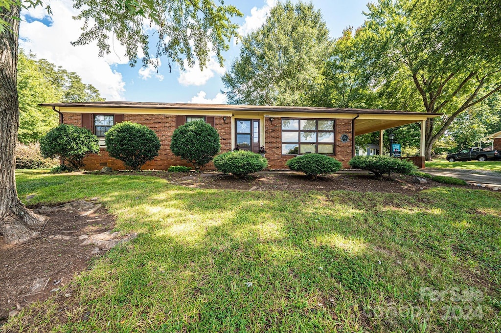 single story home featuring a front yard and a carport