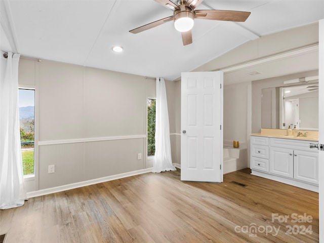 unfurnished bedroom with light wood-type flooring, lofted ceiling, multiple windows, and ceiling fan