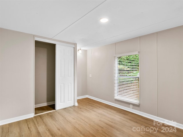 unfurnished bedroom featuring hardwood / wood-style floors and a closet