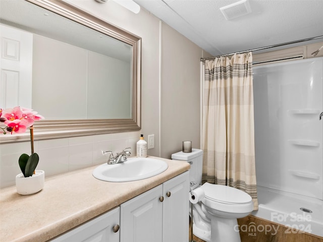 bathroom with a shower with curtain, vanity, toilet, and backsplash