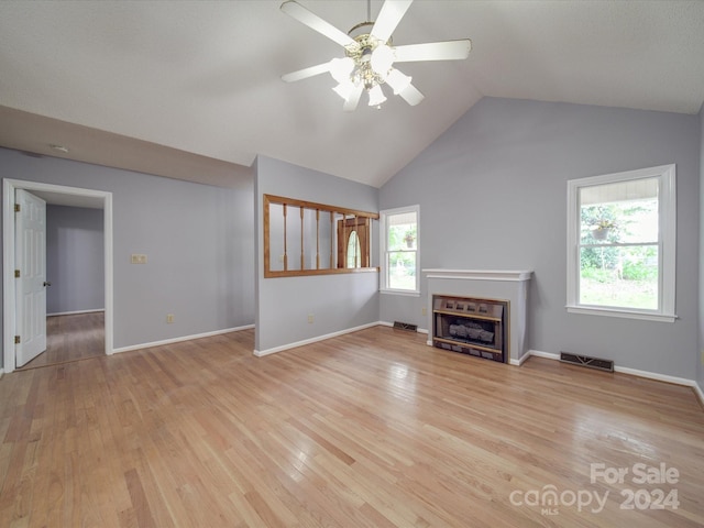 unfurnished living room with ceiling fan, light hardwood / wood-style floors, plenty of natural light, and vaulted ceiling