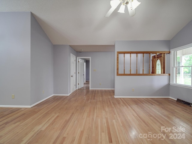 unfurnished living room with light wood-type flooring, lofted ceiling, and ceiling fan