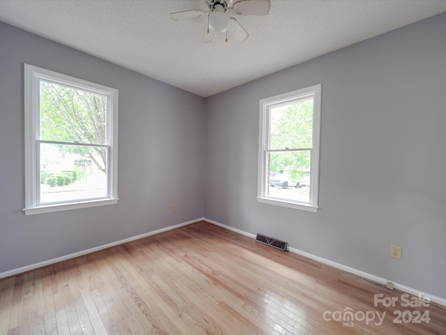 unfurnished room featuring ceiling fan, a textured ceiling, and light wood-type flooring