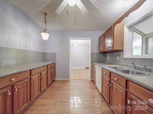 kitchen featuring white dishwasher, sink, a textured ceiling, ceiling fan with notable chandelier, and light hardwood / wood-style floors