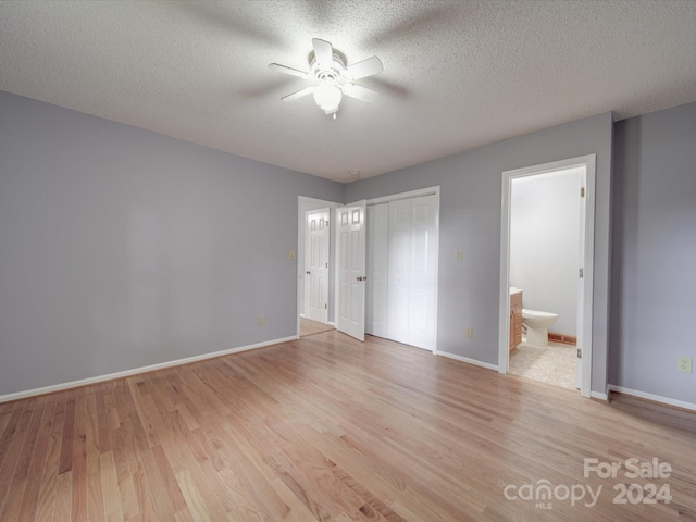 unfurnished bedroom featuring connected bathroom, light hardwood / wood-style floors, ceiling fan, and a textured ceiling