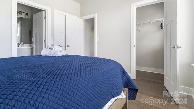 bedroom with a closet, dark hardwood / wood-style floors, and ensuite bath