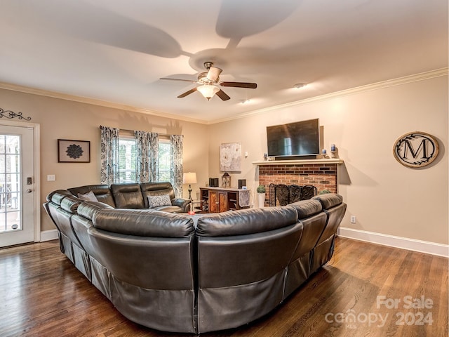 living room with ornamental molding, dark hardwood / wood-style flooring, ceiling fan, and a brick fireplace