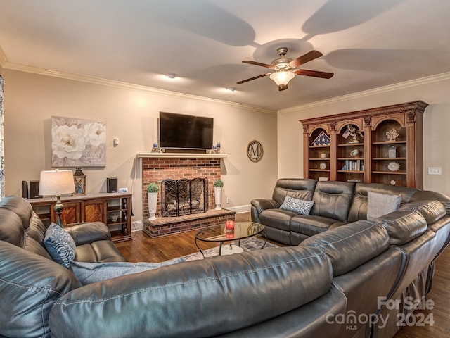 living room featuring ceiling fan, a fireplace, dark hardwood / wood-style floors, and crown molding