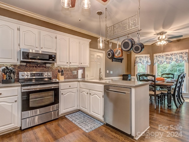 kitchen featuring dark wood-type flooring, white cabinetry, kitchen peninsula, hanging light fixtures, and appliances with stainless steel finishes