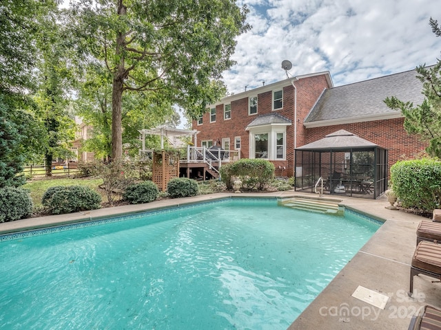 view of pool with a gazebo and a wooden deck