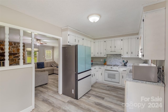 kitchen featuring light wood-type flooring, white cabinets, oven, ceiling fan, and stainless steel fridge