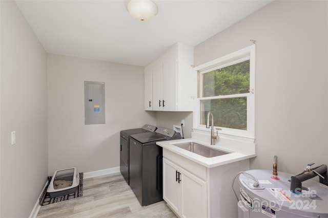 washroom with cabinets, light wood-type flooring, electric panel, sink, and separate washer and dryer