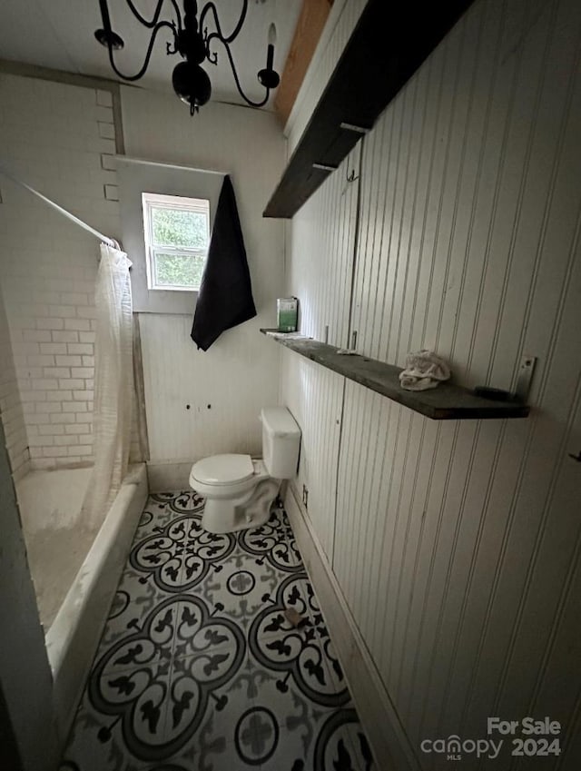 full bathroom featuring vanity, shower / bath combo with shower curtain, tile patterned floors, an inviting chandelier, and toilet