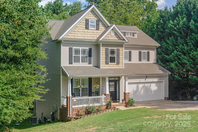 craftsman-style home with a porch, a garage, central AC unit, and a front yard