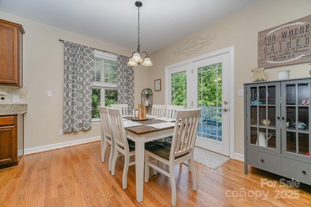 dining space featuring an inviting chandelier and light wood-type flooring