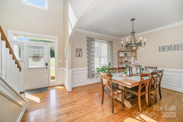 121 Canvasback Rd, Mooresville, NC 28117 - dining space with a chandelier, light wood-style floors, arched walkways, crown molding, and a wainscoted wall