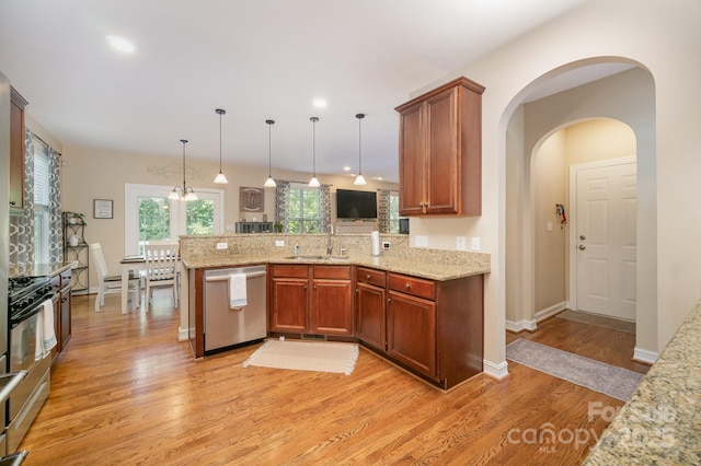 121 Canvasback Rd, Mooresville, NC 28117 - kitchen featuring appliances with stainless steel finishes, light wood finished floors, a peninsula, light stone countertops, and hanging light fixtures