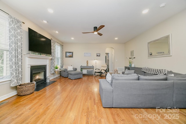 121 Canvasback Rd, Mooresville, NC 28117 - living room featuring ceiling fan, arched walkways, recessed lighting, wood finished floors, and a fireplace with flush hearth