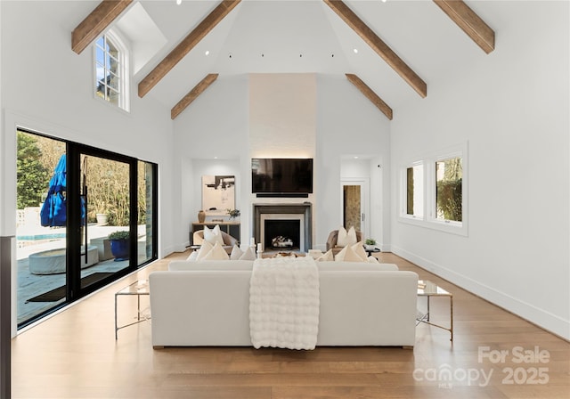 living room with beam ceiling, high vaulted ceiling, and a wealth of natural light