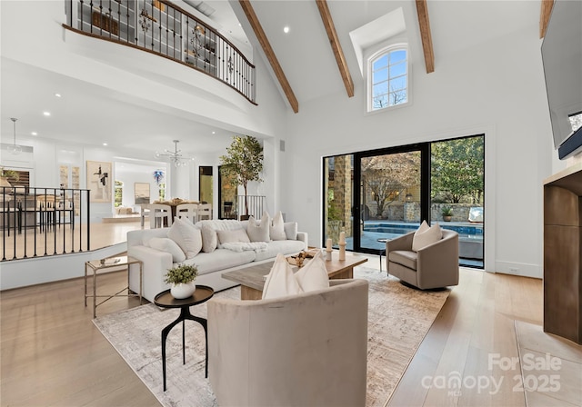 living room featuring beamed ceiling, a chandelier, light hardwood / wood-style floors, and high vaulted ceiling