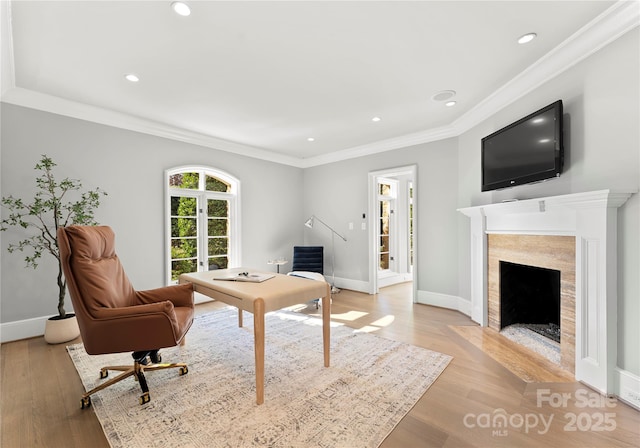 living room featuring crown molding, a high end fireplace, and light hardwood / wood-style flooring