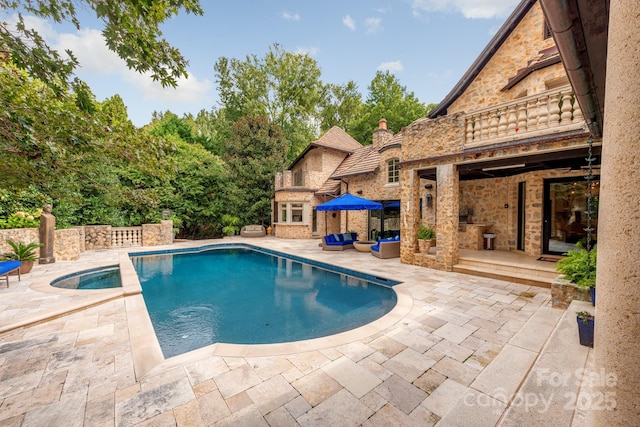 view of pool featuring a fireplace and a patio area