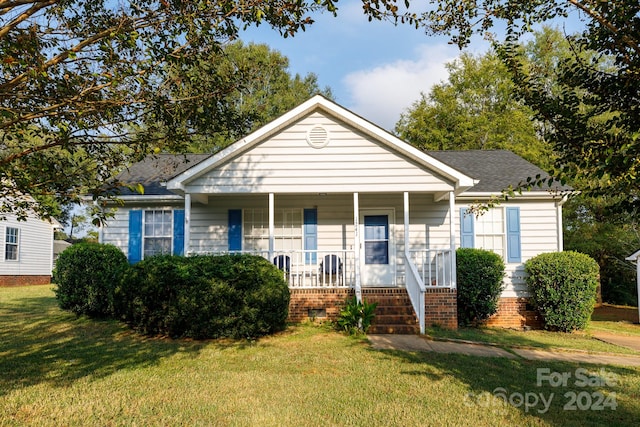 bungalow-style house with a front yard and covered porch