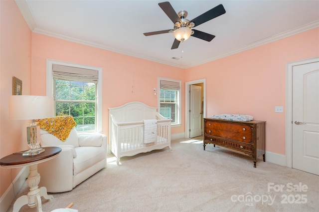 bedroom with ceiling fan, multiple windows, light carpet, a nursery area, and ornamental molding