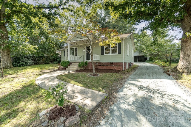 view of front facade featuring a front lawn, a carport, and covered porch