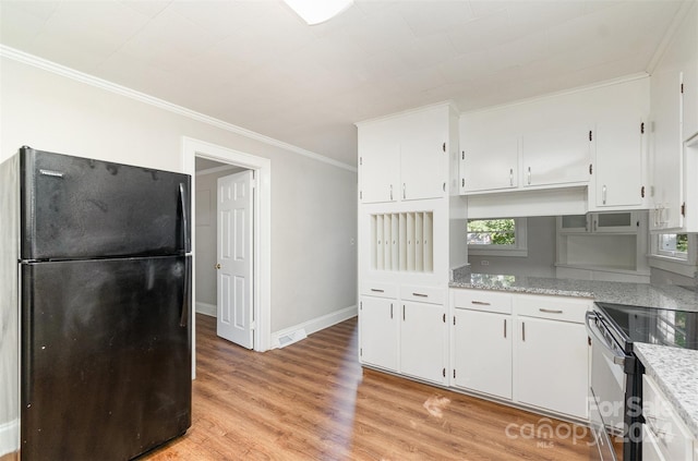 kitchen featuring light hardwood / wood-style flooring, black refrigerator, and white cabinetry