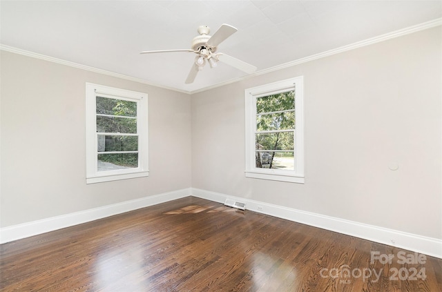 empty room featuring ornamental molding, plenty of natural light, and dark wood-type flooring