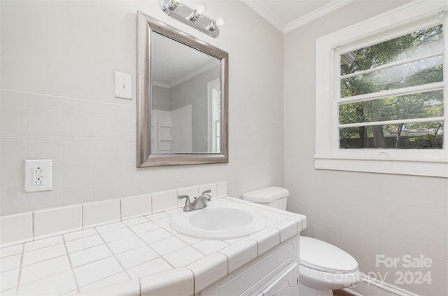 bathroom featuring tile walls, crown molding, vanity, and toilet